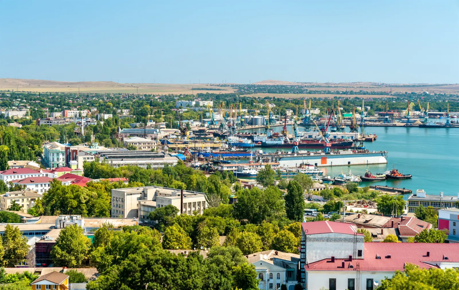 Портовый город на востоке Крыма с кранами и судами у причала